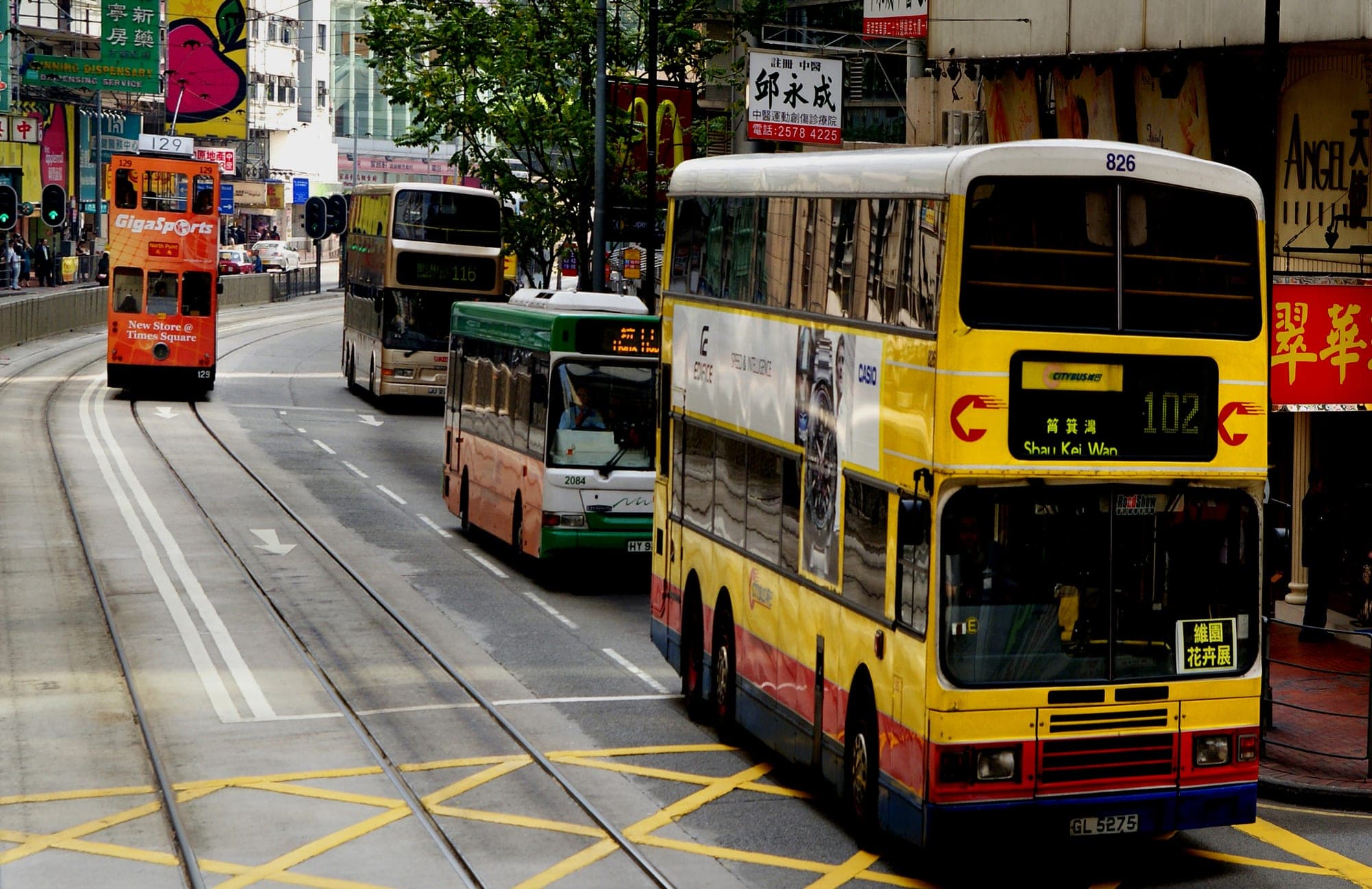 A tram and double-decker buses on a Hong Kong street
