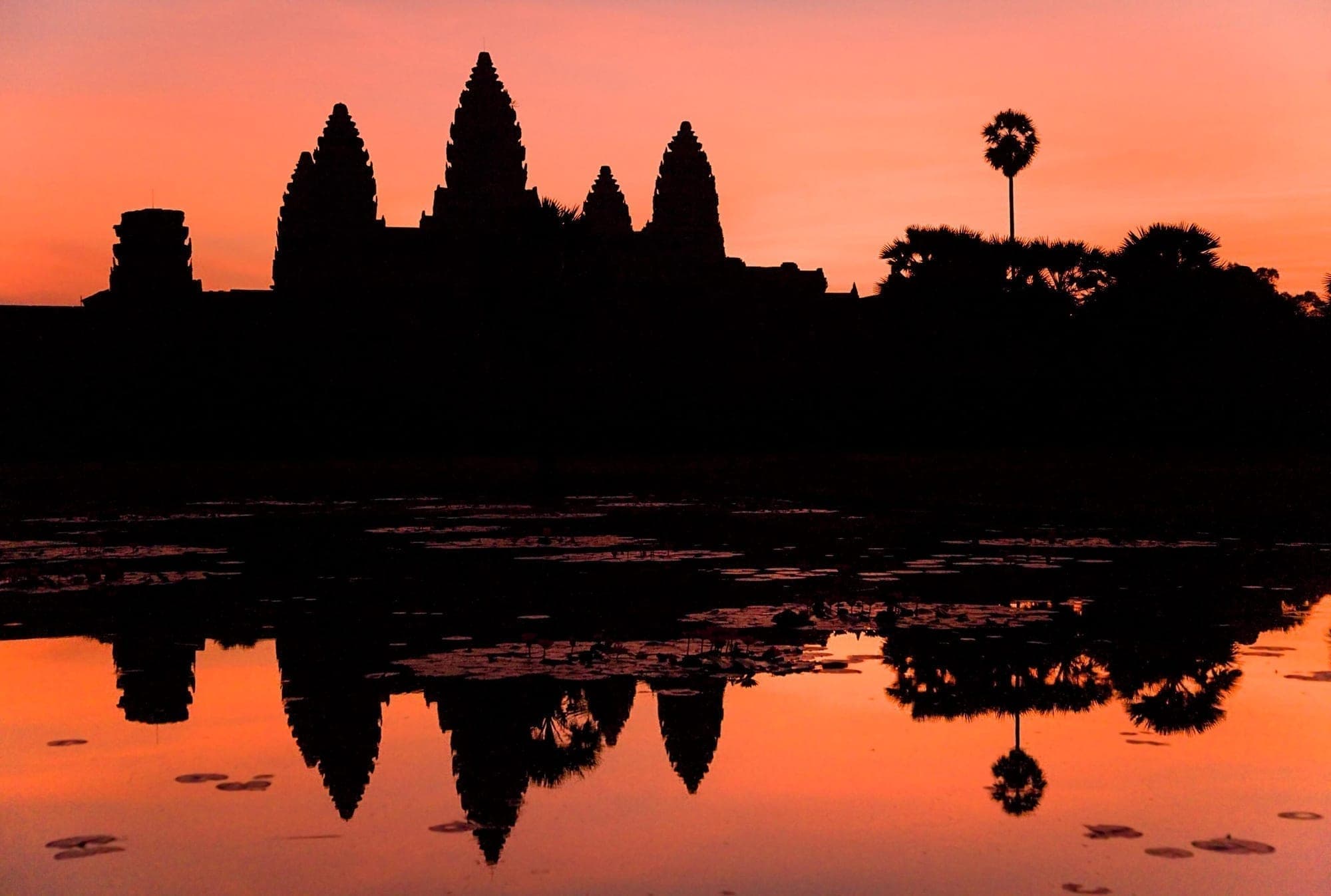 Angkor Wat silhouetted against an orange sunrise
