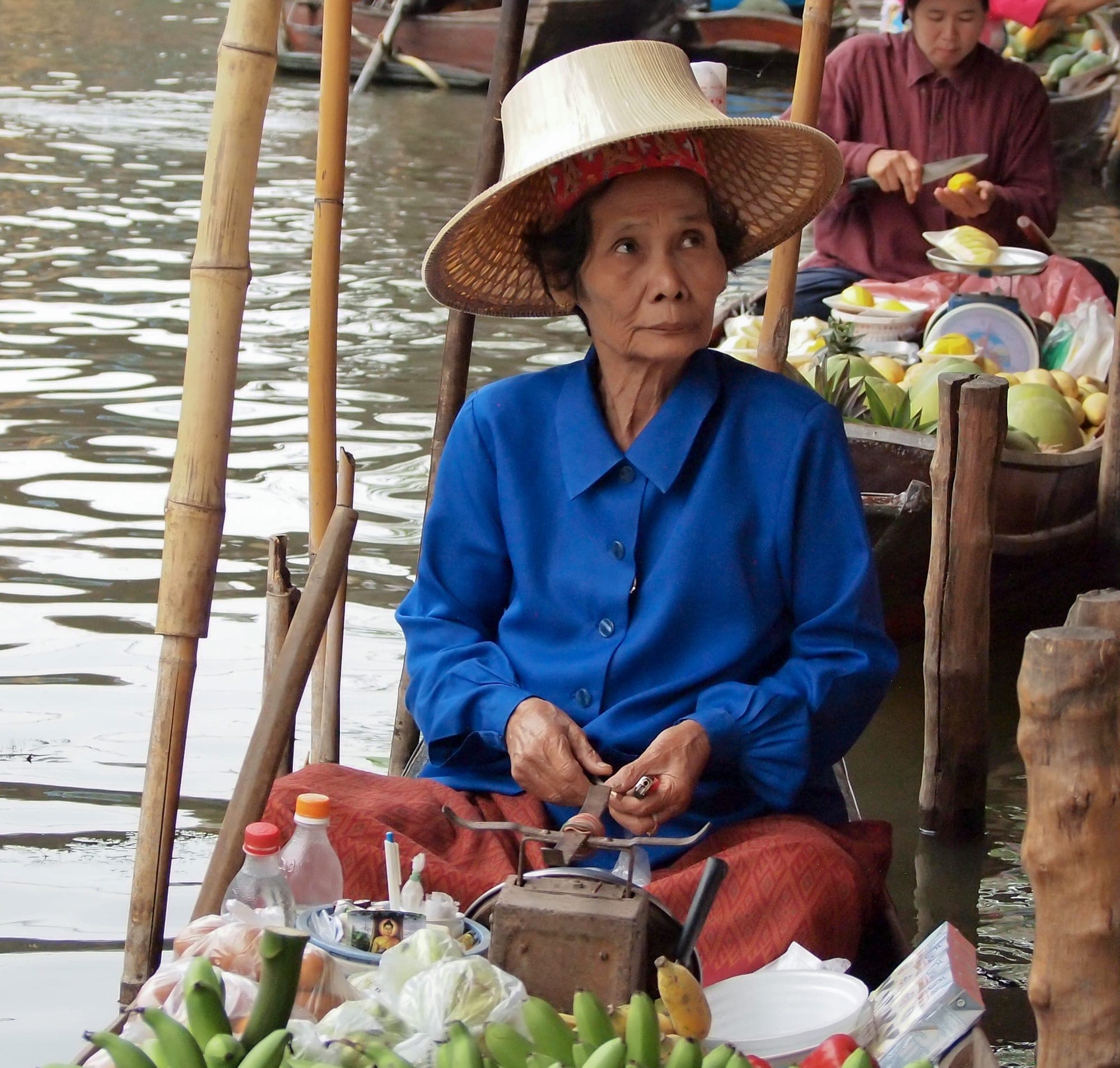 A vendor selling fruit from a boat at a floating market in Thailand