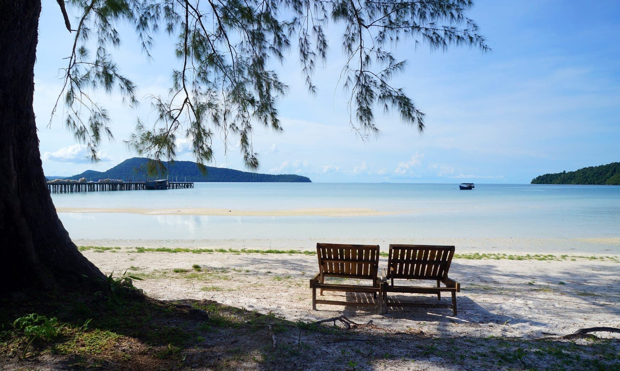 A quiet beach with benches under trees on Koh Rong
