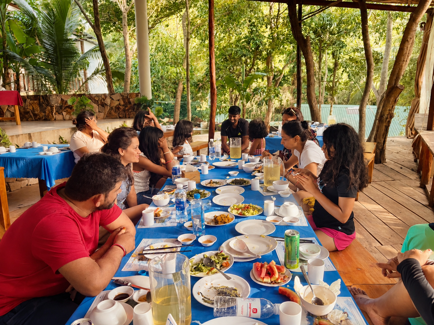 An extended family sharing a meal together at an outdoor table